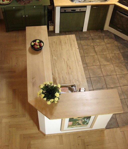 Barek dzieli salon na część kuchenną (płytki ceramiczne) i jadalnię (parkiet). Fot. ATLAS