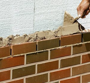 Murowanie cegieł klinkierowych można wykonać na pełną spoinę, a następnie po kilkunastu lub kilkudziesięciu minutach (w zależności od szybkości wiązania zaprawy) można przystąpić do jej profilowania. Fot. ATLAS 